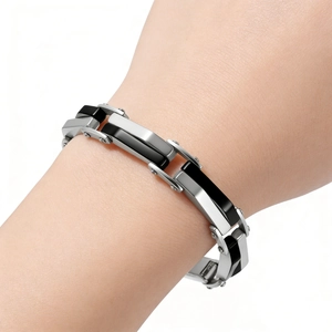 Gros plan du bracelet modulaire en acier inoxydable argent et noir au poignet masculin