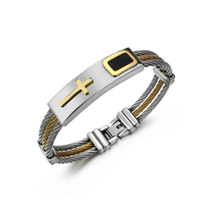 Macro view of men's braided steel wire bracelet with a golden cross on a metal plate