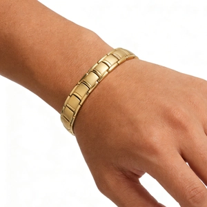 Close-up of a gold stainless steel magnetic nail bracelet on a male wrist with polished finish