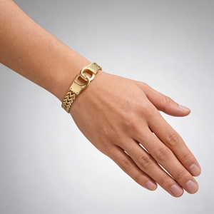 Detail of gold handcuff clasp on a curb chain bracelet worn on a male wrist