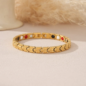 Detail of gold-plated energy bracelet showing textured surface and colored health magnets