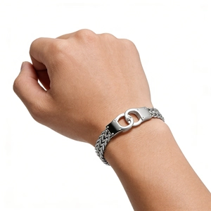 Close-up of silver stainless steel handcuff link bracelet on male wrist with curb chain