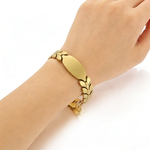 Close-up of gold wheat leaf chain bracelet with smooth engravable ID plate on wrist