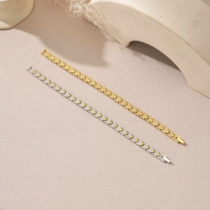 Gold and silver health energy magnetic therapy bracelets on a minimalist stone surface