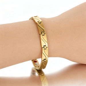 Detail eines goldenen Magnetarmbands mit Wellentextur und eingelegten Therapiemagneten