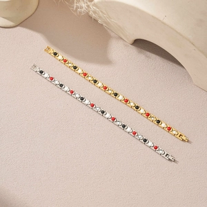 Detail of gold and silver magnetic therapy bracelets with colorful stone insets