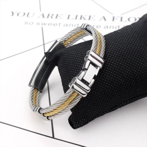 Three-row steel cable braided bracelet in gold and silver with polished metal clasp