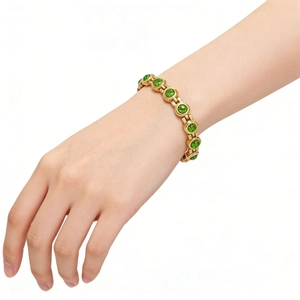 Vue détaillée d'un bracelet doré orné de zircons verts étincelants de taille ronde