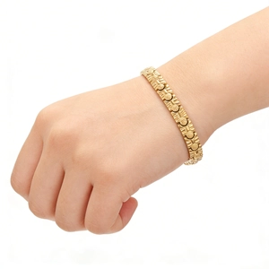 Detail of a gold-plated magnetic energy bracelet on a model wrist against white background