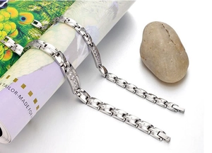 Dettaglio di bracciali in acciaio al titanio con zirconi cubici su maglie a forma di H
