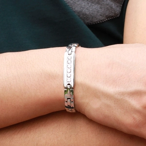 Dettaglio di un bracciale a maglie in acciaio inossidabile argento con sei zirconi al polso