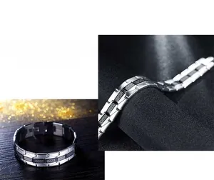 Macro detail of silver stainless steel bracelet featuring black Greek meander motifs