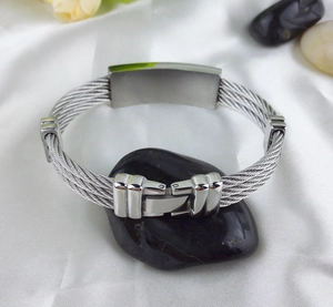 Detailed macro view of woven stainless steel bracelet with a polished engravable plate