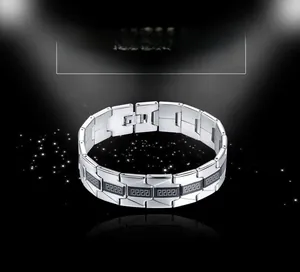 Macro shot of stainless steel watchband-style bracelet with black Greek key pattern