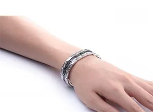 Detail of silver stainless steel Greek key bracelet showing the buckle on a male wrist