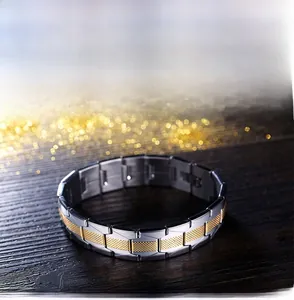 Close-up of two-tone stainless steel men's bracelet with gold grid on dark wood