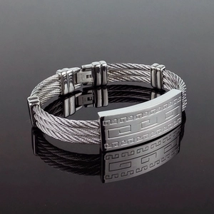 Detailed macro view of triple-strand stainless steel woven bracelet with meander pattern