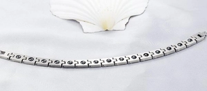 Detailed macro view of silver titanium steel magnetic therapy bracelet with black magnets