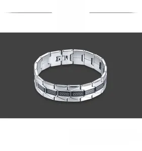Macro detail of stainless steel bracelet featuring Greek key pattern and fold-over clasp