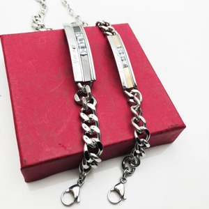 Bracelets de couple en acier titane gravés présentés sur un coffret rouge