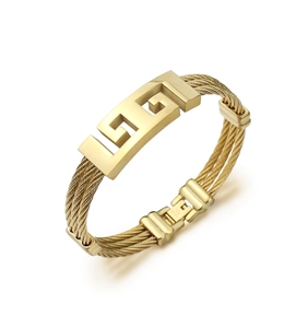Macro detail of gold triple-strand braided stainless steel bangle with geometric pattern