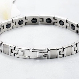 Titanium steel health bracelet with magnetic stones on a white silk background