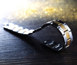 Men's two-tone stainless steel bracelet with black and gold textured watchband links
