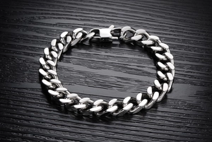 Close-up of classic polished stainless steel Cuban link bracelet on a dark background