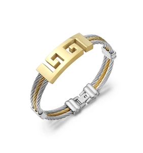 Close-up of two-tone braided steel wire bracelet with gold geometric pattern detail