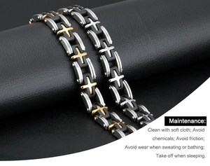Detailed macro view of men's steel bracelets with cross design on black leather display