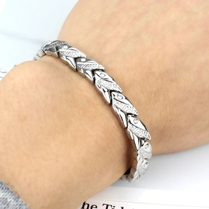 Gros plan d'un bracelet magnétique en acier titane argenté avec maillons givrés et strass