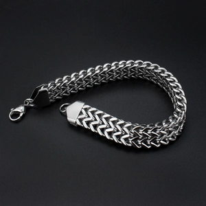 Detail of silver men's titanium steel bracelet with lobster clasp and woven chain texture