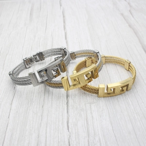 Three-piece set of woven steel cable bracelets with geometric cutout fretwork design