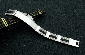 Detailed close-up of men's titanium steel bracelet with black Greek key patterns