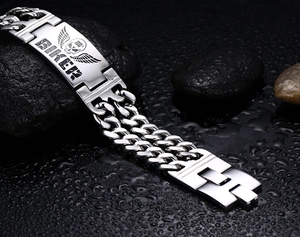 Detailed close-up of biker skull bracelet with double chain on wet stones