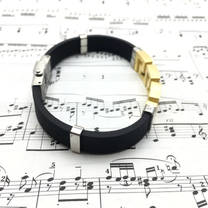 Close-up of silicone bracelet with gold Greek fret pattern and silver buckle detail