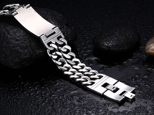 Men's titanium steel double row curb chain bracelet with ID tag on wet pebbles