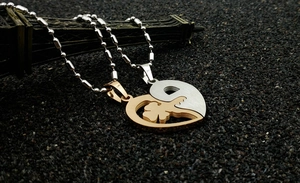 Macro detail of heart and key puzzle pendant necklace in gold and silver finish