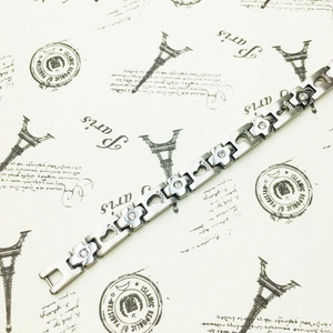 Detail of titanium steel bracelet with pavé crystal flowers and hollow footprints