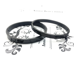 Detail of minimalist black titanium steel couple bracelets with side buckle closure