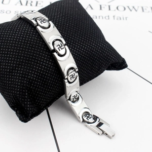 Bracelet en acier titane poli avec motif swastika noir sur un coussin d'affichage chic