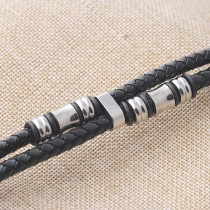 Gros plan détaillé d'un bracelet en cuir tressé noir double couche avec perles en métal poli