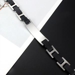 Macro detail of men's titanium steel bracelet with black silicone and engravable plate
