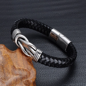 Detail of men's black braided leather bracelet with silver metal knot and magnetic clasp