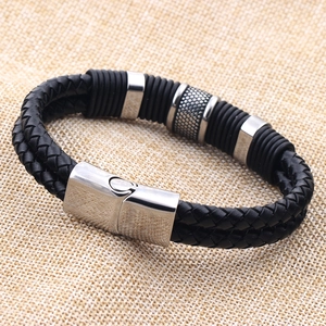 Detail of men's braided leather bracelet with silver metal charms and magnetic clasp