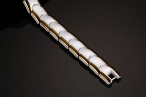 Fashionable white ceramic and gold-plated metal link bracelet for women on black background