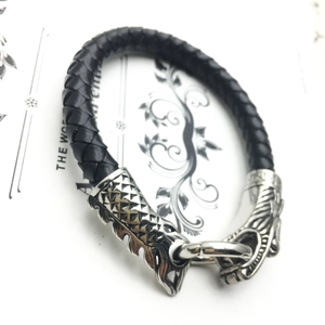Détail du bracelet en cuir tressé noir avec fermoir tête de dragon en argent poli