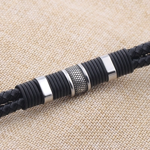 Close-up of black braided leather bracelet featuring silver metal tubes and spiral rings