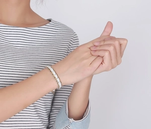 Elegant gold metal and white ceramic linked bracelet for women on wrist studio shot