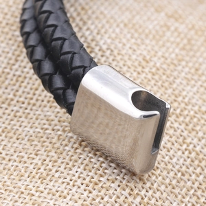 Detailed macro view of the silver brushed steel clasp and black braided leather strap